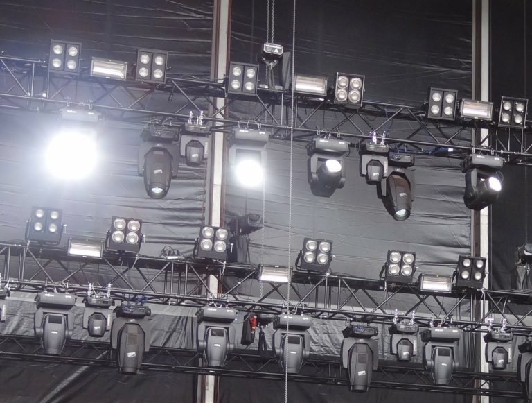 Traversen mit zahlreichen Scheinwerfern und Moving Heads vor schwarzem Bühnenmolton