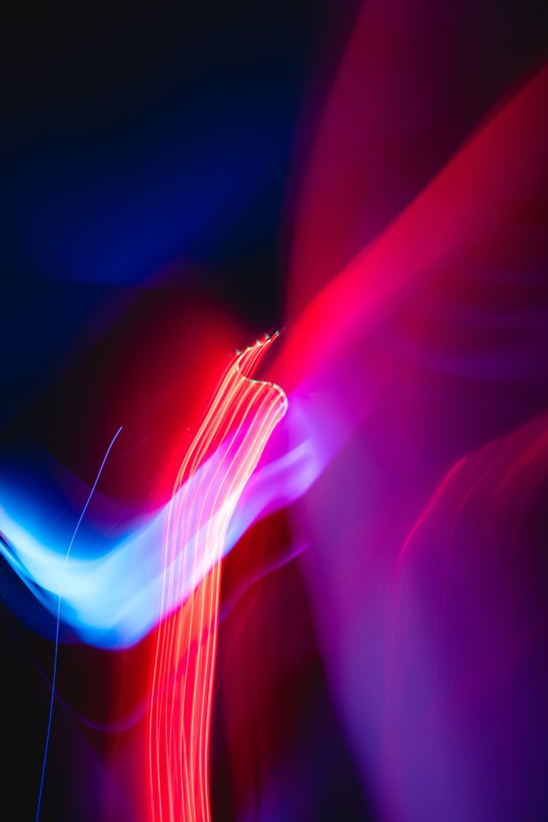 Abstrakte rote und blaue Lichtspuren auf dunklem Hintergrund